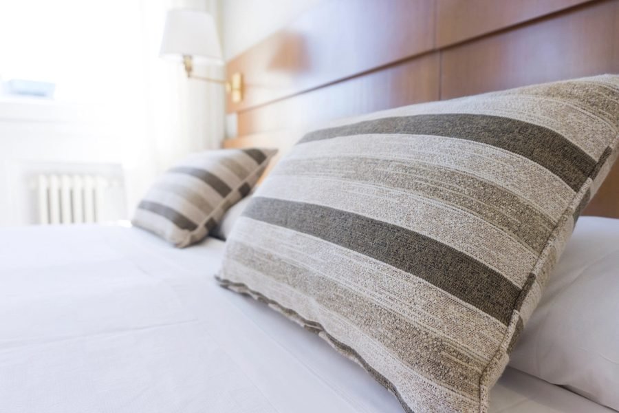 Crisp white pillows on a made hotel bed