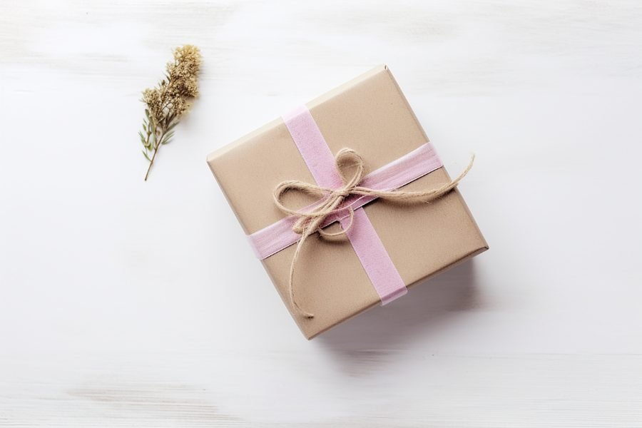 A kraft paper gift box tied with a soft pink ribbon